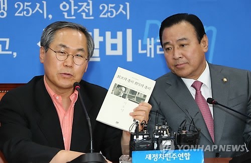 ▲ 새정치민주연합 우윤근 원내대표가 26일 국회 야당 원내대표실에서 자신을 찾아온 이완구 국무총리 내정자에게 새누리당 정두언 의원의 저서인 '최고의 총리, 최악의 총리'를 선물하고 있다. ⓒ연합뉴스