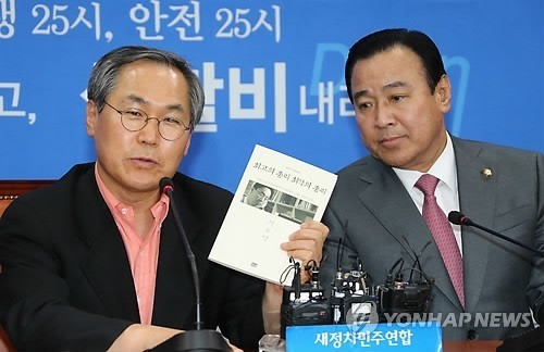 ▲ 새정치민주연합 우윤근 원내대표가 26일 국회 야당 원내대표실에서 자신을 찾아온 이완구 국무총리 내정자에게 새누리당 정두언 의원의 저서인 '최고의 총리, 최악의 총리'를 선물하고 있다. ⓒ연합뉴스