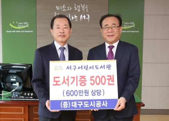 ▲ 대구도시공사(사장 이종덕, 오른쪽)가 창사 20주년을 맞아 서구 어린이도서관에 도서 500권을 기증했다. 기증식에서 이종덕 사장과 류한국 서구청장이 기념촬영을 하고 있다.ⓒ대구도시공사 제공