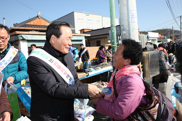 ▲ 설 제수용품 구매를 위해 전통시장을 찾은 주민과 인사나누고 있는 김주수 군수ⓒ뉴데일리