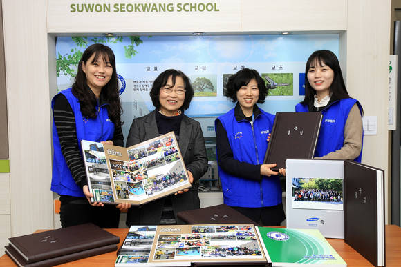 ▲ 수원서광학교 한정애 교장에게 삼성SDI 임직원들이 졸업앨범을 증정하고 있는 모습 ⓒ삼성SDI