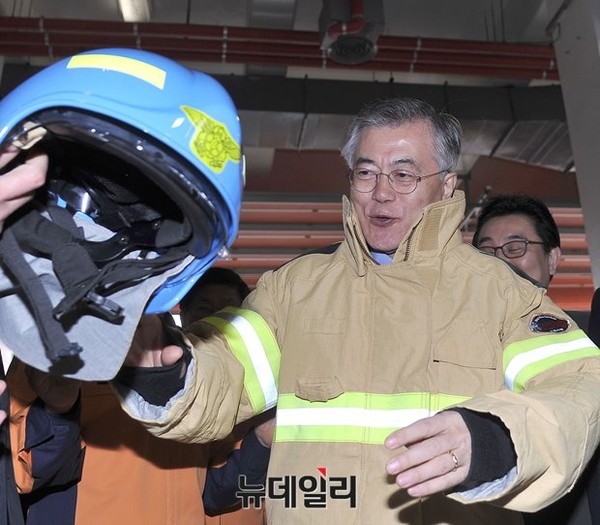 ▲ 문재인 새정치연합 대표가 설 연휴를 하루 앞둔 17일 오전 동작소방서를 방문해 옷을 입어 보고 있다. ⓒ뉴데일리 정재훈 기자