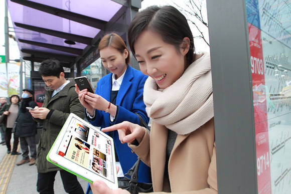 ▲ 버스정류장에서 KT 기가와이파이를 이용해 고객들이 다양한 멀티미디어 서비스를 즐기고 있는 모습.ⓒKT