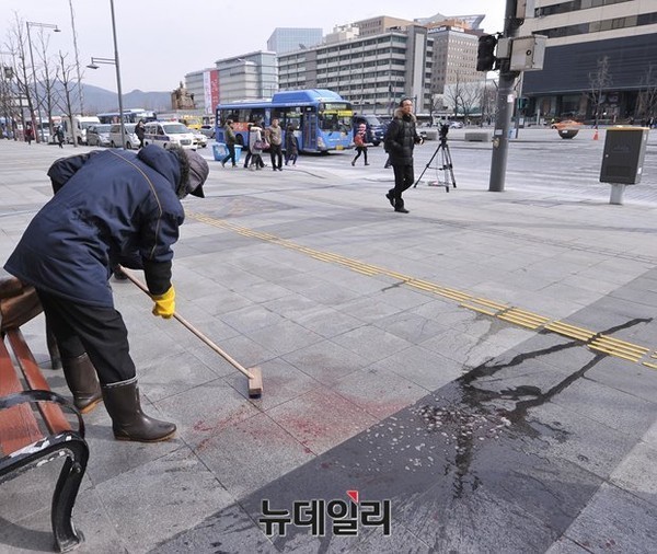 지난 5일 마크 리퍼트 주한 美대사에 대한 테러가 일어난 서울 광화문 세종문화회관 앞을 관계자들이 청소하는 모습. ⓒ뉴데일리 정재훈 기자