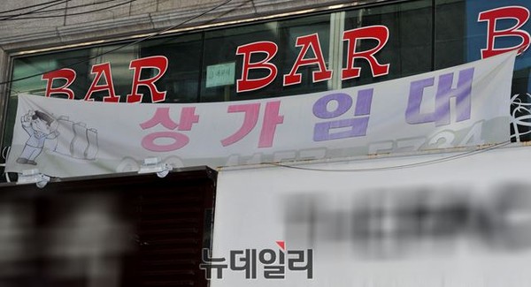 ▲ 새누리당 김무성 대표최고위원과 오신환 예비후보가 23일 신림동 고시촌을 돌며 지역 주민 및 상인들과 인사를 나눈 가운데, KB국민은행ATM 앞 사거리 인근의 한 상가 건물에 공실 있음을 알리는 플랭카드가 붙어 있다. ⓒ뉴데일리 이종현 기자