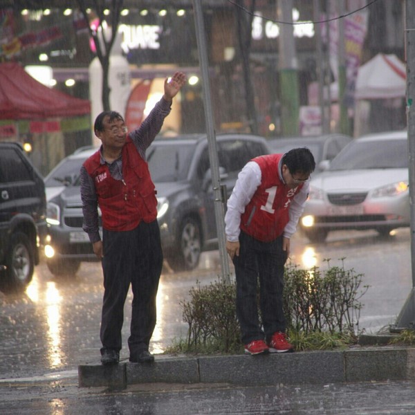 ▲ 4.29 광주 서구을 보궐선거에 출마한 새누리당 정승 후보와 이정현 최고위원이 4일 민생투어 중 폭우 속에서 시민들에게 지지를 호소하고 있다. ⓒ 정승 후보 선거사무소 제공