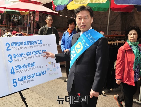 ▲ 새정치민주연합 정태호 후보가 8일 관악 세이브마트 앞에서 자신의 선거 정책을 담은 피켓을 두고 정책발표 기자회견을 하고 있다. 곁으로 지역 유권자들이 지나다니고 있다.  ⓒ뉴데일리 이종현 기자