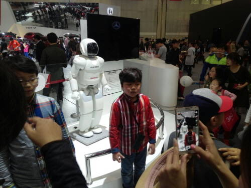 ▲ 혼다의 '아시모쇼'가 끝난 후 부스에 전시된 아시모 로봇과 한 아이가 기념촬영을 하고 있다.ⓒ뉴데일리