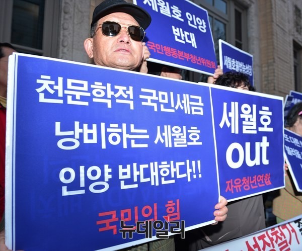 ▲ 세월호 인양 반대 피켓을 든 집회 참가자 ⓒ뉴데일리