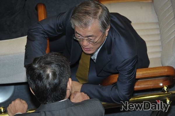 ▲ 국회 본회의장에서 동료 의원과 대화하고 있는 문재인 새정치민주연합 대표.ⓒ뉴데일리DB