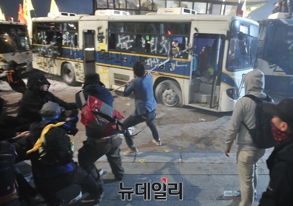 ▲ 지난 18일 서울 광화문 일대에서 벌어진 세월호 폭력시위 당시, 시위대들이 경찰버스를 훼손한 뒤, 끈으로 버스를 묶어 전복을 시도하고 있다. ⓒ 뉴데일리 이종현 기자