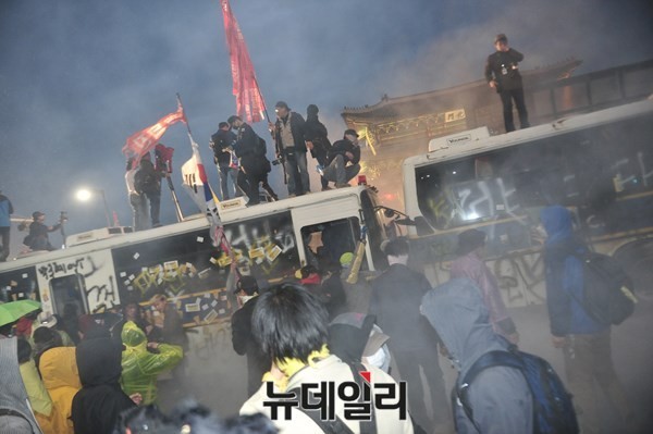 지난 18일 서울 광화문 일대에서 벌어진 세월호 폭력시위 현장. 시위대들이 경찰버스를 부순 뒤 위에 올라가 깃발을 흔들고 있다. ⓒ 뉴데일리 이종현 기자