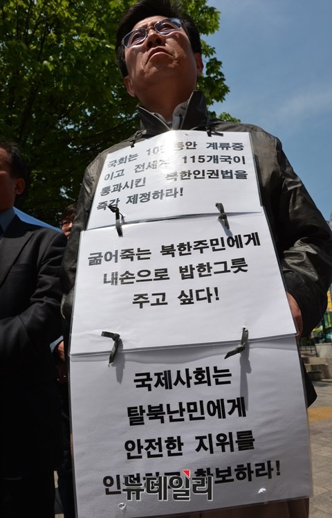 ▲ 집회 참가자가 북한인권법의 조속한 제정을 촉구하는 피켓을 목에 걸고 있다. ⓒ뉴데일리 정상윤 기자