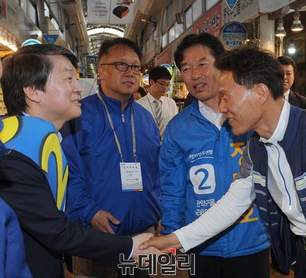 ▲ 새정치민주연합 안철수 전 공동대표가 29일 전통시장을 찾아 시민과 악수하고 있는 가운데, 민병두 민주정책연구원장과 정태호 후보가 이를 바라보고 있다. ⓒ뉴데일리 정재훈 기자