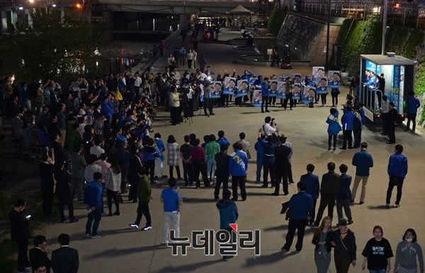▲ 새정치민주연합 정태호 후보가 28일 저녁 9시 55분 도림천수변공원에서 집중 유세를 끝낼 무렵의 전경. 정태호 후보의 피켓을 든 선거운동원들이 유세차량 오른쪽에 벽을 이루고 있어, 보행자들이 좁은 통로로 지나다녀야 하는 형편이다. ⓒ뉴데일리 정상윤 기자