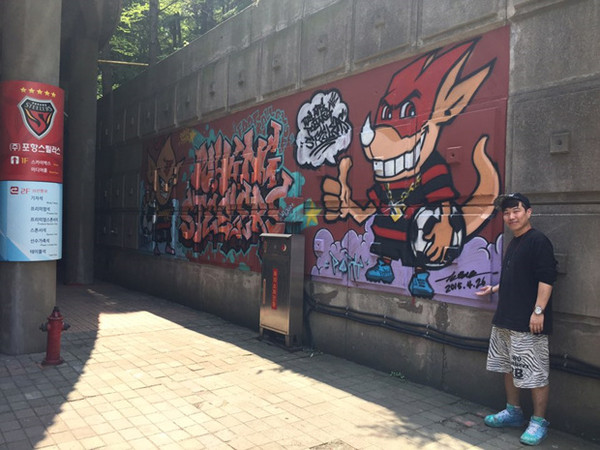▲ 그래피티 작가 김현조 씨가 자신의 작품 앞에서 사진 촬영을 하고 있다.ⓒ포항 스틸러스