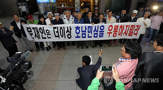 ▲ 새정치민주연합 문재인 대표가 광주로 향한 4일, 20여 명의 광주시민이 광주공항 승강장에 모여 문재인 대표를 규탄하는 현수막을 펼친 채 항의를 준비하고 있다. ⓒ연합뉴스 사진DB