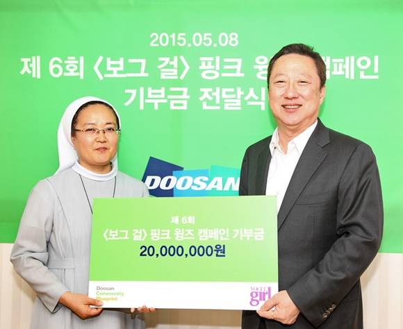 ▲ 박용만 두산그룹 회장(右)이 윤미숙 알퐁시아 수녀에게 '두산매거진 보그걸 핑크 윙즈 캠페인' 수익금 2000만원을 전달하고 있다. ⓒ두산