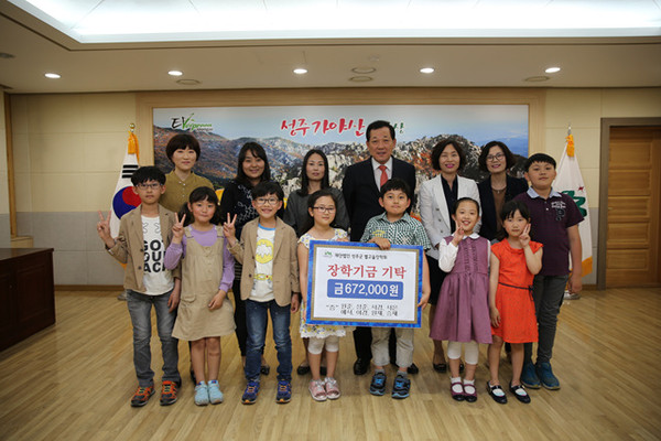 ▲ 성주중앙초 학생들이 어린이날 카페를 열어 마련한 수익금을 장학금으로 기부하고 김항곤 군수와 기념촬영을 하고 있다.ⓒ성주군 제공