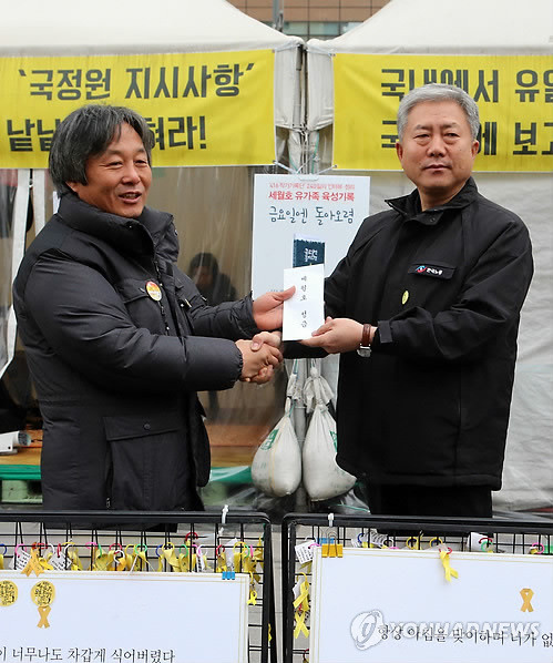 ▲ 올해 1월26일, 김동만 한국노총 위원장으로부터 성금을 받고 있는 박래군 위원장(사진 왼쪽). ⓒ 사진 연합뉴스