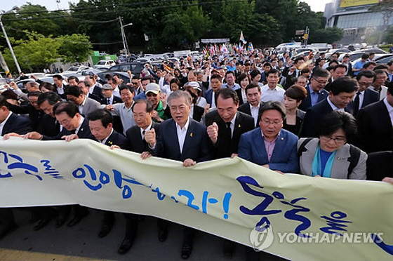 ▲ 새정치민주연합 문재인 대표가 17일 5·18 전야 민주대행진을 하는 과정에서 팔뚝질을 하며 [민주를 인양하라 통일을 노래하라]라는 구호를 따라 외치고 있다. ⓒ연합뉴스 사진DB