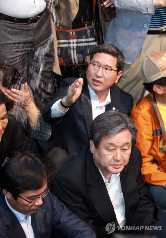 ▲ 17일 광주 금남로에서 열린 5·18 전야제에 참석한 새누리당 김무성 대표최고위원을 향해 물이 끼얹어지고 있는 가운데, 김학용 대표비서실장이 손을 들어 이를 가려보려 하고 있다. ⓒ연합뉴스 사진DB