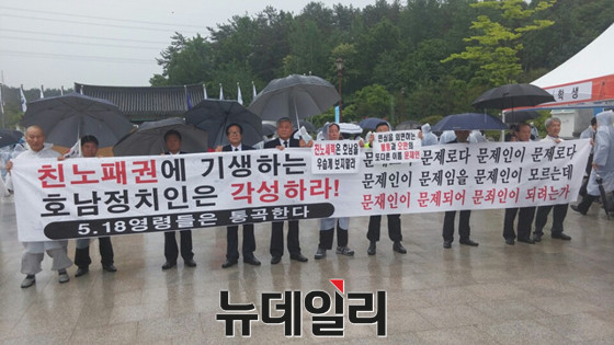 ▲ 새정치민주연합 문재인 대표가 18일 국립 5·18 묘역에서 열린 공식 기념식에 참석하고 나올 때에 맞춰, 광주시민들이 플래카드를 들고 [문재인은 사퇴하라]라는 구호를 외치고 있다. ⓒ뉴데일리 이길호 기자