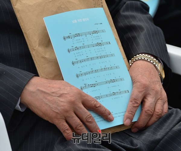 ▲ 5.18 서울기념사업회는 18일 오전, 서울광장에서 5.18 민주화운동 35주년을 맞아, '5.18 민주화운동 제35주년 서울기념식'을 열었다. 한 참석자가 ‘임을 위한 행진곡’ 악보를 들고 있는 모습. ⓒ뉴데일리 정상윤 기자