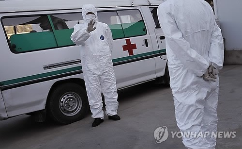 ▲ 방호복을 입은 북한의 의료진이 앰뷸런스 옆에 대기하는 모습. ⓒ 연합뉴스