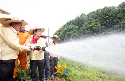 ▲ 15일 오후 화성 남양읍을 방문한 남경필 경기도지사가 채인석 화성시장과 논에 용수를 공급하고 있다. ⓒ경기도 사진제공