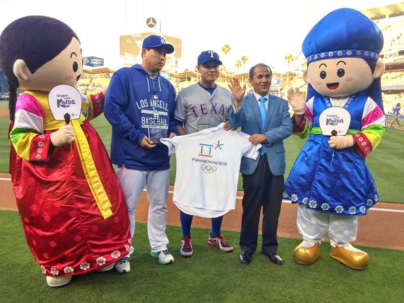 ▲ 류현진 선수와 추신수 선수가 올림픽 엠블럼이 인쇄된 티셔츠를 들어 보이며 현지 관중들에게 평창동계올림픽을 홍보하고 있는 모습.ⓒ한국관광공사