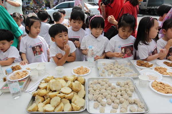▲ 어린이들이 보리 주먹밥과 보리개떡, 미숫가루, 피감자, 건빵 5종류의 전쟁음식을 무료로 시식하고 있다.ⓒ예천군 제공