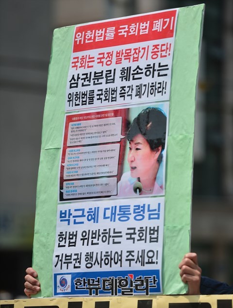 ▲ 한 어버이연합 회원이, 위헌 논란을 빚고 있는 국회법 개정안에 대한 거부권 행사를 바라는 글귀가 적힌 손 피켓을 들고 있다. ⓒ 뉴데일리 정상윤 사진기자