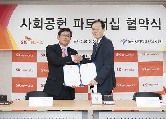 ▲ 박성수 SK네트웍스 홍보실장(左)과 박준석 노원시각장애인복지관장이 협약식을 체결한 후 악수를 나누고 있다. ⓒSK웍스