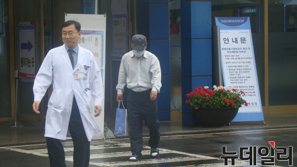 ▲ 대구 메르스 확진환자 A씨(오른쪽)가 26일 오전 경북대병원 후문에서 나와 구급차로 향하고 있다. A씨는 아무 말없이 모자에 마스크를 쓴 채 집으로 향했다.ⓒ뉴데일리