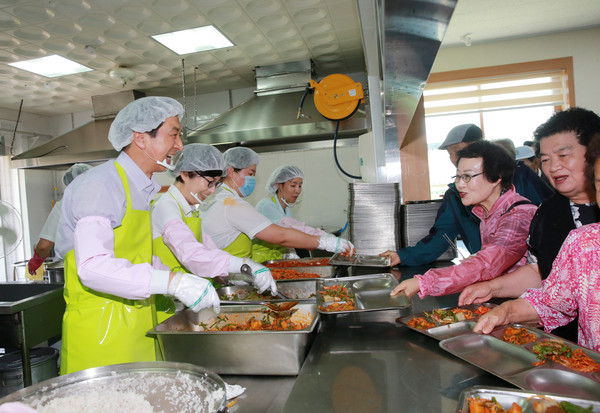 ▲ 김기현 시장이 부인과 함께 직접 배식 복장을 갖추고 식당을 찾은 어르신들에게 반찬 배식을 하며, 시민들의 의견을 경청하는 장면=울산시제공ⓒ뉴데일리