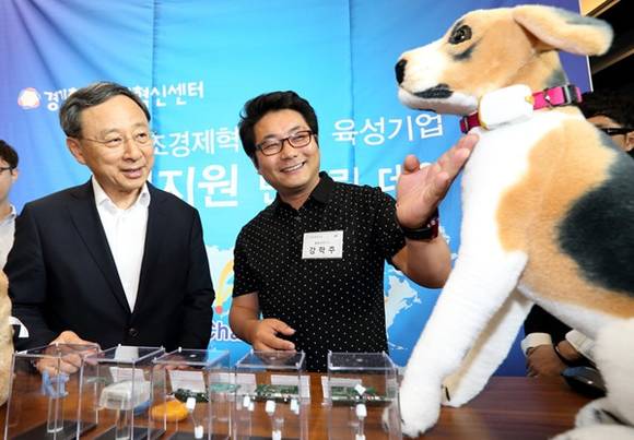 ▲ KT 황창규 회장과 경영진이 ‘울랄라 연구소’의 강학주 대표에게 비콘과 통신모듈을 활용한 반려견 위치 확인 및 반려견 케어서비스 설명을 듣고 있는 모습.ⓒKT