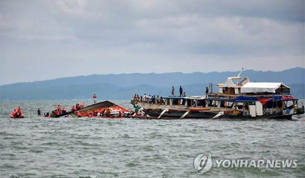 ▲ 항구에서 불과 200m 떨어진 곳에서 전복된 필리핀 연안 여객선과 이를 구조하는 다른 선박의 모습. ⓒ연합뉴스. 무단전재 및 재배포 금지.