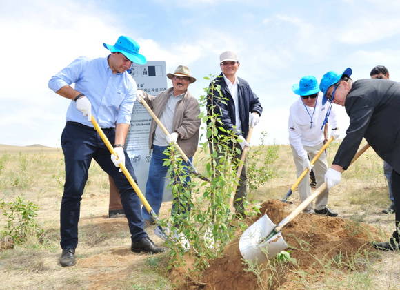 ▲ ) 지난 7일 카스 희망의 숲에서 유엔사막화방지협약(UNCCD, United Nations Convention to Combat Desertification)이 수여하는 ‘2014 생명의 토지상’을 수상한 것을 축하하는 기념행사가 열렸다. 오비맥주 김도훈 사장(오른쪽)이 몽골 수도 울란바토르시 바트에르덴 부시장(왼쪽)으로부터 사막화 방지에 기여한 노력을 인정받아 감사패를 수상하고 기념촬영을 하고 있다.ⓒ오비맥주