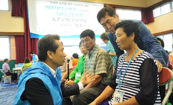 ▲ NH농협생명 김용복 대표이사(사진왼쪽) 와 구룡농협 최재욱 조합장(사진 왼쪽에서 세번째)이 충남 부여군에서 실시된 100번 째 순회진료에서 어르신들에게 도움을 주고 있다.ⓒNH농혒행명 제공