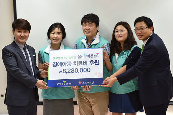 ▲ 고병옥 교보다솜이지원센터장(사진 오른쪽) 등 교보생명 임직원들이 한일웅 푸르메재단 종로아이존 센터장(사진 왼쪽)에게 기부금을 전달하고 있다.ⓒ교보생명 제공