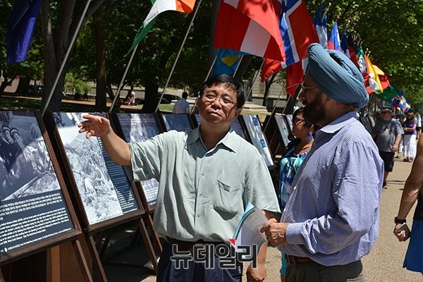 ▲ 안재철 월드피스자유연합 이사장(왼쪽)이 24일부터 미국 워싱턴 백악관 앞에서 열린 '생명의 항해 6.25전쟁 사진전'에서 관람객과 대화를 나누고 있다. ⓒ월드피스자유연합