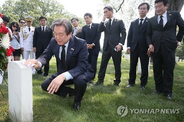 ▲ 새누리당 김무성 대표최고위원이 27일(한국시각) 미국 워싱턴DC의 알링턴 국립묘지 내에 소재한 월튼 워커 중장의 묘역을 찾은 자리에서 손수건을 꺼내 손수 워커 장군의 묘비를 정성껏 닦아내고 있다. 이후 김무성 대표는 한국식으로 큰절을 두 번 올리는 재배를 하며, 워커 장군의 낙동강 전선 사수에 감사의 뜻을 표했다. ⓒ연합뉴스 사진DB