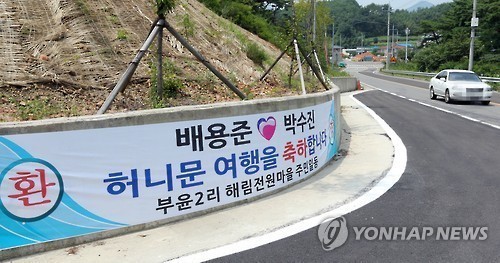 ▲ 배우 배용준과 박수진 부부가 28일 신혼여행지로 선택한 경남 남해군 창선면 한 고급 골프리조트로 가는 길에 두사람의 결혼 축하와 신혼여행을 환영하는 플래카드가 내걸렸다.이 플래카드에는 리조트 인근 전원마을 주민 일동이라고 적었다.  ⓒ 연합뉴스