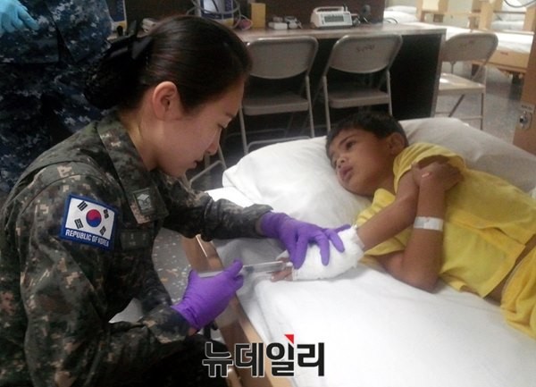 ▲ 합동 의료지원팀 박희진 소위가 현지 아동 환자에게 주사를 놓고 있다. ⓒ해군