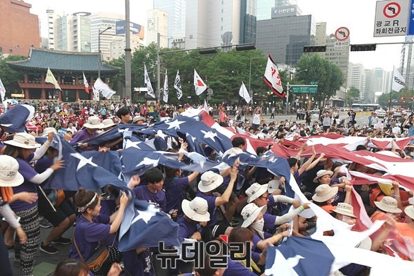 15일 오후 서울 도심에서 벌어진 좌파단체의 8.15기념 행사에 참석한 시위대가, 종각 근처에서 성조기와 일장기를 합친 형태의 기(旗)를 찢는 퍼포먼스를 벌이고 있다. ⓒ 뉴데일리 윤진우 기자