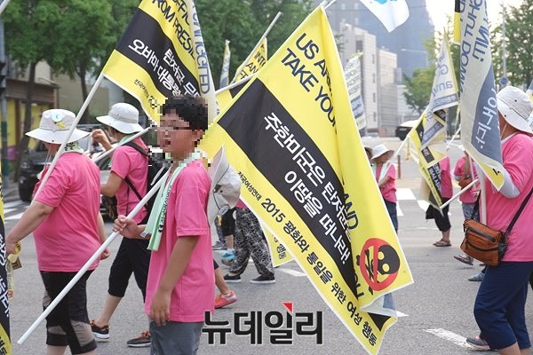 ▲ 초등학생으로 보이는 한 어린 참가자가 주한미군 철수를 요구하는 내용의 깃발을 들고 거두행진에 참가한 모습. ⓒ 뉴데일리 윤진우 기자