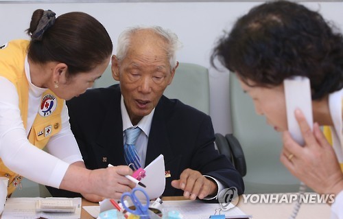 ▲ 추석 계기 이산가족 상봉을 논의하는 남북 적십자 실무접촉이 이뤄진 7일 오전 서울 중구 소파로 대한적십자사 본사 이산가족민원실에서 한 이산가족 신청자가 자원봉사자와 서류를 확인하고 있다.ⓒ 연합뉴스