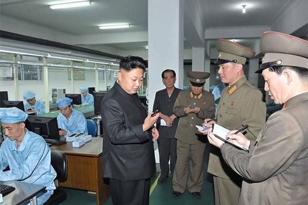 ▲ 휴대전화 공장을 찾은 김정은의 모습. 살찐 손 때문에 휴대전화가 작아 보인다. ⓒ北선전매체 보도화면 캡쳐