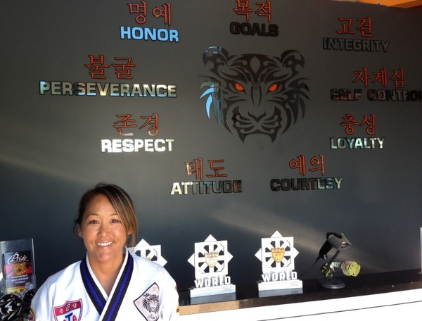 ▲ 도장 주인이자 교장인 엘리자멧 안씨와 그가 만든 태권도 정신목표 9가지 동판, 영문과 한글로 병기되어있다.